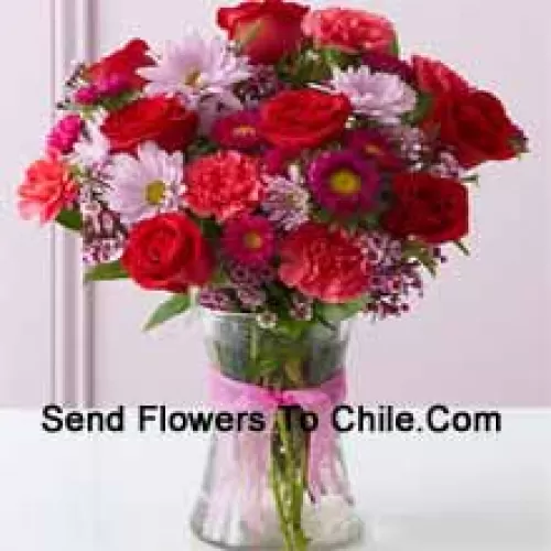 Red Roses, Red Carnations And Other Assorted Flowers Arranged Beautifully In A Glass Vase