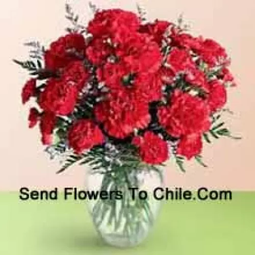 37 Red Carnations With Seasonal Fillers In A Glass Vase